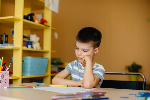 A school-age boy does homework at home. Training at school - Φωτογραφία, εικόνα
