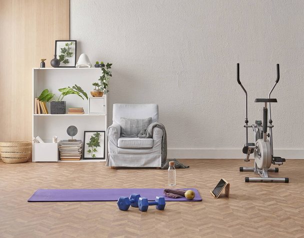 Training at home concept, interior, decorative sport in the room with gym fitness exercise purple mat, dumbbell and bicycle. - Photo, Image