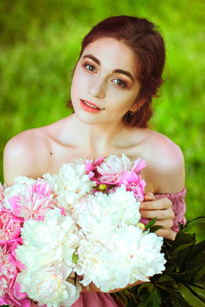 Outdoor portrait of young redhead woman in nature with big bouquet of pink peonies. Woman's Day. Female spring, summer fashion concept. - Fotoğraf, Görsel