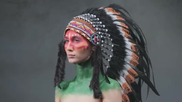 Gyönyörű nő törzsi indián fejdísz sötét füstös háttér - Felvétel, videó