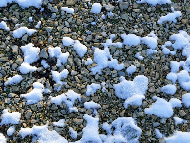 Сніговий залишок на гальці взимку в Німеччині. - Фото, зображення