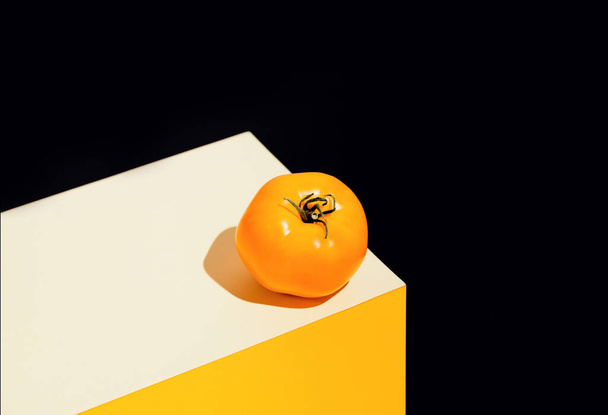 Verse sinaasappeltomaat op geometrische kleurrijke achtergrond. Gezond voedselingrediënt geschikt voor veganisten en vegetariërs. Biologisch groenteconcept - Foto, afbeelding