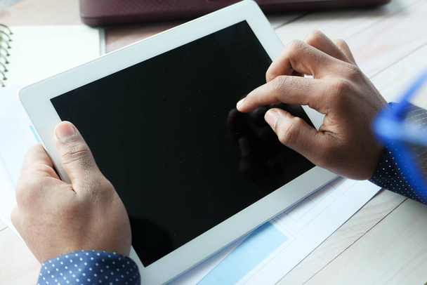  vista trasera del hombre de negocios utilizando tableta digital en el escritorio de la oficina  - Foto, Imagen