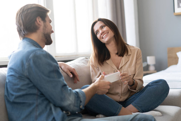 Young woman receiving a surprise gift box from her boyfriend at home. - 写真・画像