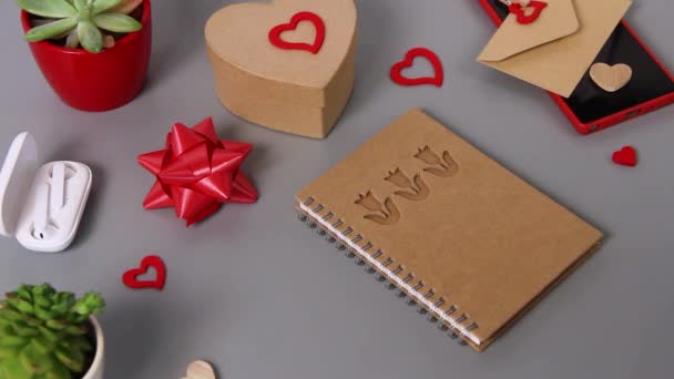 Quelqu'un ouvre un carnet avec des lettres JE VOUS AIME et coeur près de la carte de Saint-Valentin et présente - Séquence, vidéo