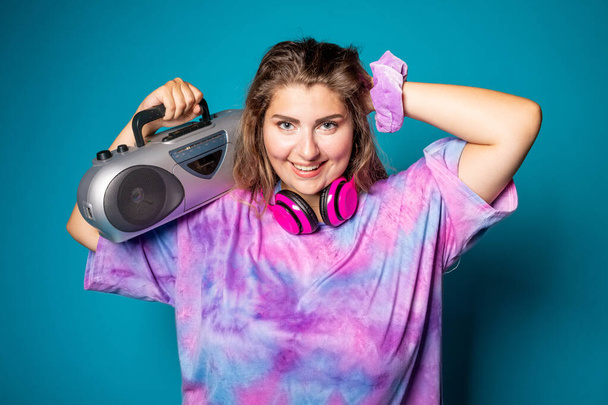 Junge Plus Size mollige Frau auf blauem Hintergrund tanzt mit Stereoanlage Musik hören isoliert Studioaufnahme - genießen, Vielfalt, Körper positives Konzept - Foto, Bild