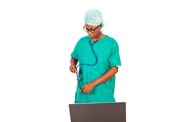 młoda lekarka trzymająca stetoskop i pracująca na laptopie w szpitalu. - Zdjęcie, obraz