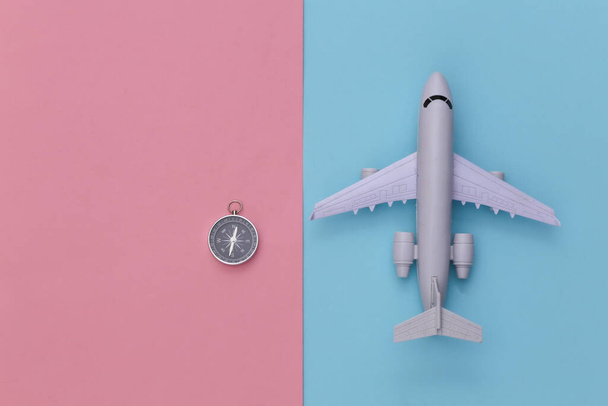 Minimalismo viaggio piatto laici. Bussola e aereo su sfondo blu-rosa pastello. Vista dall'alto - Foto, immagini