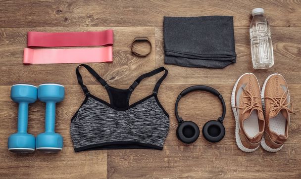 Flat lay composition of Sports equipment, clothes on a wooden floor. Fitness, sport and healthy lifestyle concept. Top view - Photo, Image