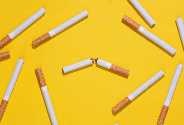 Cigarrillo roto sobre fondo amarillo brillante. Dejar de fumar - Foto, Imagen