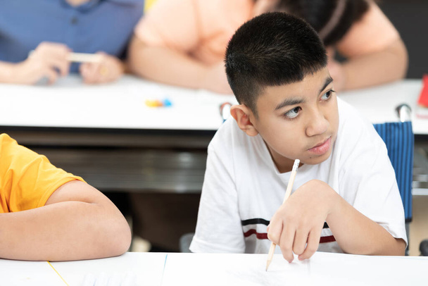 Asiatische behinderte Kinder oder autistische Kinder, die am Schreibtisch im Klassenzimmer lesen und schreiben lernen - Foto, Bild