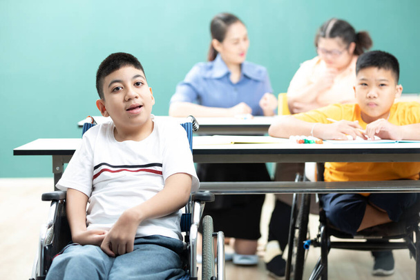 ritratto asiatico disabili bambini o autismo bambino seduto su una sedia a rotelle in aula - Foto, immagini