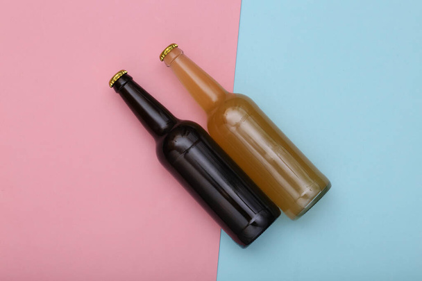 Bottle of light and dark beer on pink blue background. Top view - Foto, imagen