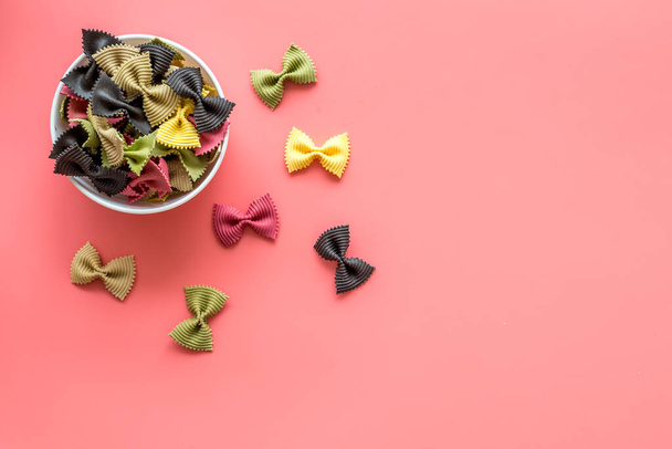 Coloured farfalle pasta in bowl, top view - Foto, afbeelding