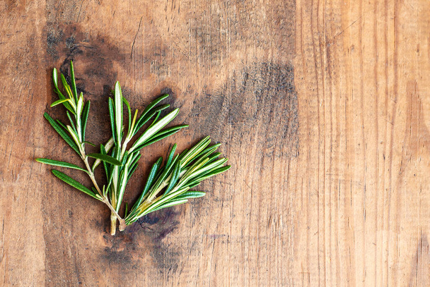 Fresh rosemary herb on wooden  background. Top view rosemary with  copy space - Foto, imagen