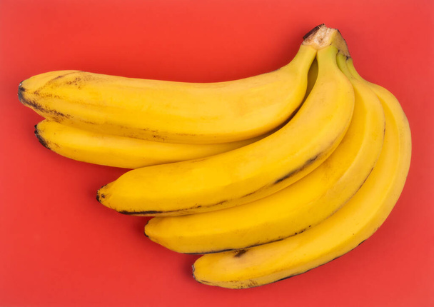 bunch of bananas on red background - Photo, Image