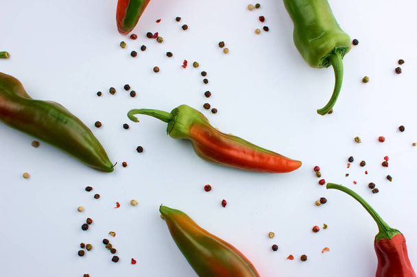 Allspice beans. Colored grains of pepper. Seasoning. A pod of hot red unripe pepper. On white background. - Fotografie, Obrázek