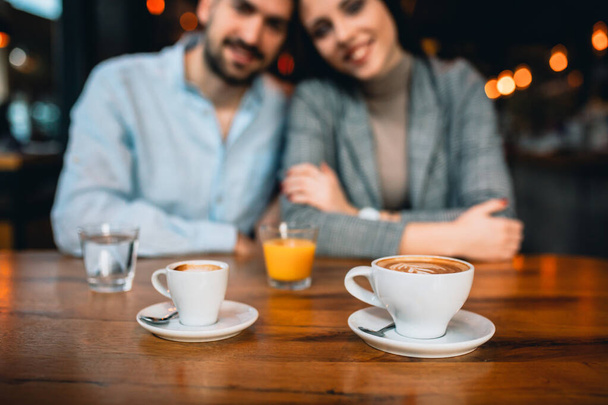 close up of espresso coffee, romantic couple in blurred background - Fotoğraf, Görsel