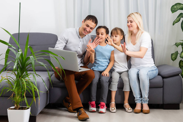 Молодая счастливая случайная семья из двух детей и пары, сидящих на диване и смотреть смешное видео или мультфильмы в тачпаде - Фото, изображение