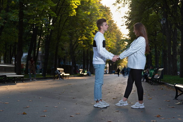 恋人たちはお互いを見て、秋の公園で手をつないで - 写真・画像