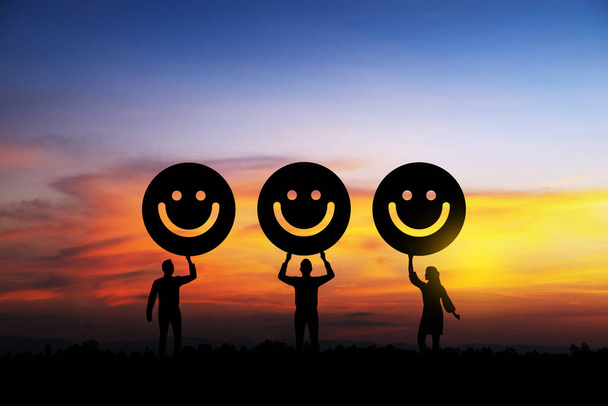 Silhouette emberek kezében mosoly arc érzelem színes drámai ég naplementekor. Szolgáltatásminősítés, elégedettségi koncepció - Fotó, kép