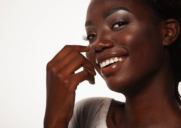 Lifestyle, emotion and people concept: Close up portrait of happy young african woman laughing over white background - Фото, изображение