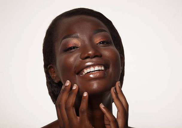 Lifestyle, emotion and people concept: Close up portrait of happy young african woman laughing over white background - Photo, Image
