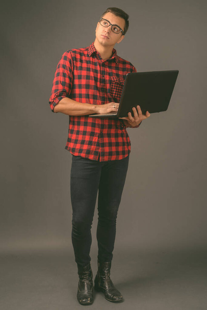 Studioaufnahme eines jungen gutaussehenden Mannes vor grauem Hintergrund - Foto, Bild