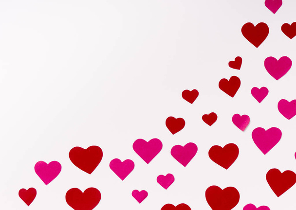 Top view on red and pink paper hearts in corner on white background with copy space - Photo, Image