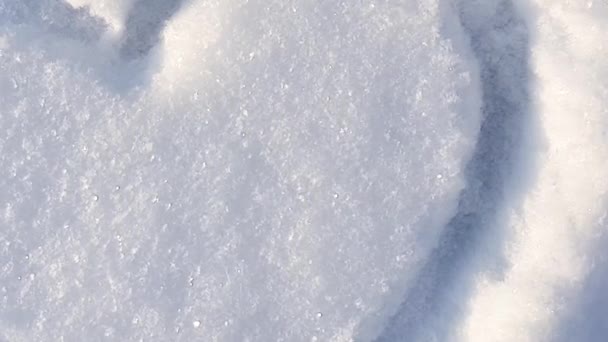 Vidéo 4K, un cœur dessiné sur la neige dans le parc. Jour de la Saint-Valentin, zoom caméra lente - Séquence, vidéo