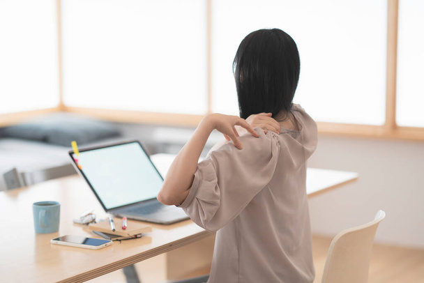 Женщина, которая заботится о жестких плечах, работая из дома - Фото, изображение