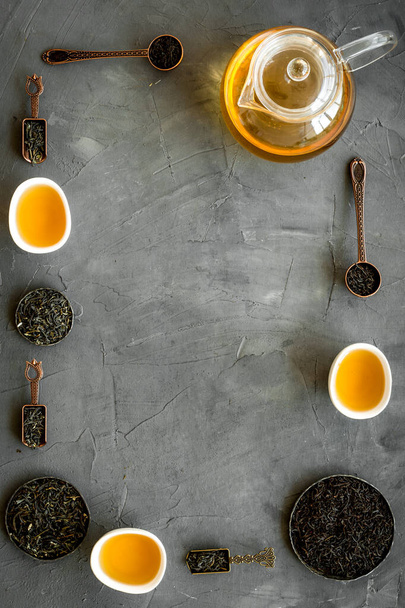 Frame of hot and dry tea in teapot and cups. Tea ceremony concept - Zdjęcie, obraz