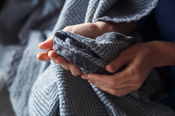 A girl holds a soft warm blue cotton blanket in her hands - Fotó, kép
