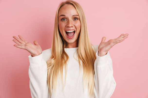 Excited beautiful girl posing with throwing up hands isolated over pink background - Fotografie, Obrázek