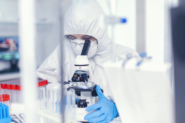 Επιστήμονας με αποστειρωμένη στολή προστασίας που αναλύει τον ιό της στέψης - Φωτογραφία, εικόνα