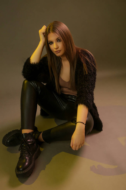Fashionable young woman in black outfit on grey background, studio shot - 写真・画像