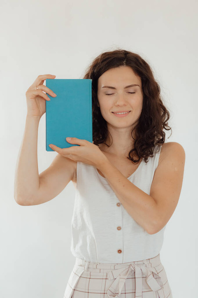 young woman holding book in hands - Foto, imagen
