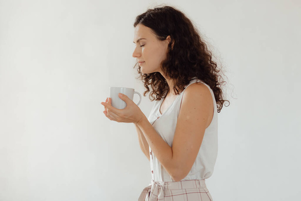 giovane donna che beve caffè e mangia una tazza di tè - Foto, immagini