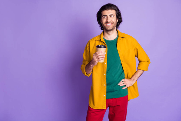 Photo of young arabian man hold cup of coffee enjoy smile look empty space isolated over purple color background - Фото, изображение