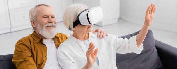 Smiling man hugging wife in vr headset on couch, banner  - Photo, Image