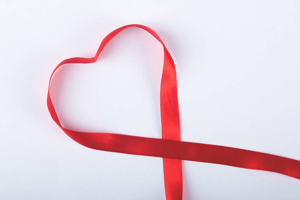 Valentines day background with red bow forming heart. - Foto, afbeelding