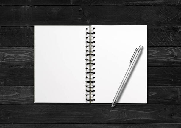 Blank open spiral notebook and pen mockup isolated on black wood background - Foto, Bild