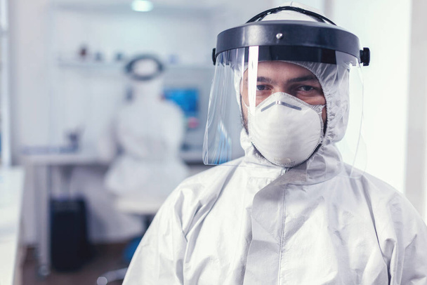 Ιατρικό προσωπικό που φοράει προστατευτικό εξοπλισμό στο εργαστήριο για την έρευνα covid - Φωτογραφία, εικόνα