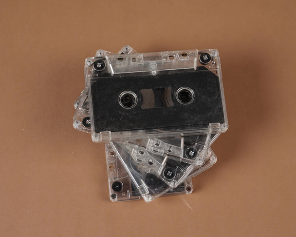 カラフルなオーディオカセットテープの束。数年前のアンティークのオーディオカセットはまだうまくいっています。オーディオ録音とオーディオカセット形式の再生、トップビューの古い技術. - 写真・画像