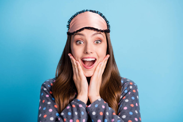 Closeup headshot photo of model teenager cute young girl hands cheeks open mouth surprised invited sleepover party wear mask dotted shirt pajamas sleepwear isolated blue color background - Photo, image