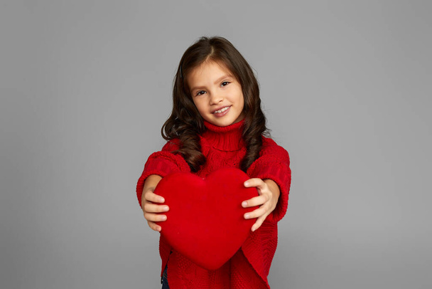 smiling child girl holding red heart - 写真・画像