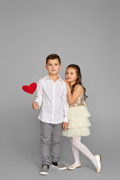 Happy couple little girl and boy with red hearts - Фото, изображение
