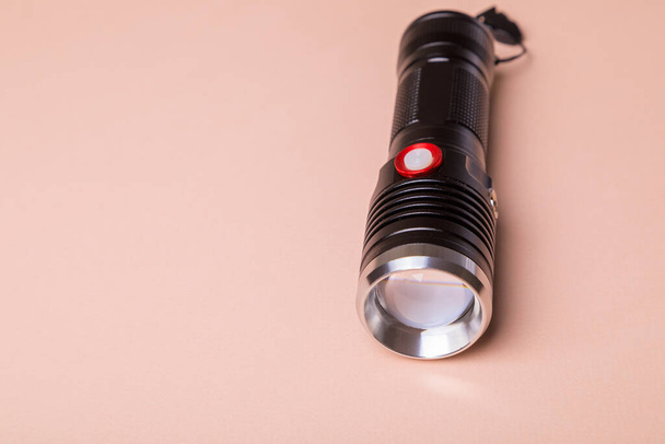 The light for the photographer is durable, powerful, made of aluminum. Flashlight on a pink background - Foto, Bild