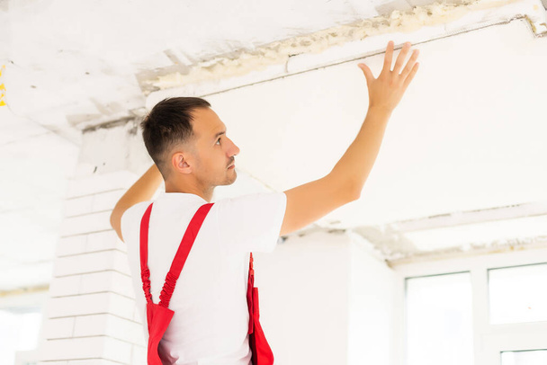 Young man fixing ceiling insulated. Renovation, construction - Foto, Imagem