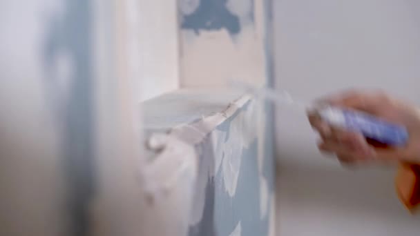 Рука держит штукатурку инструмент улучшения дома. нанесение штукатурки на угол стены с лопаткой, крупным планом - Кадры, видео